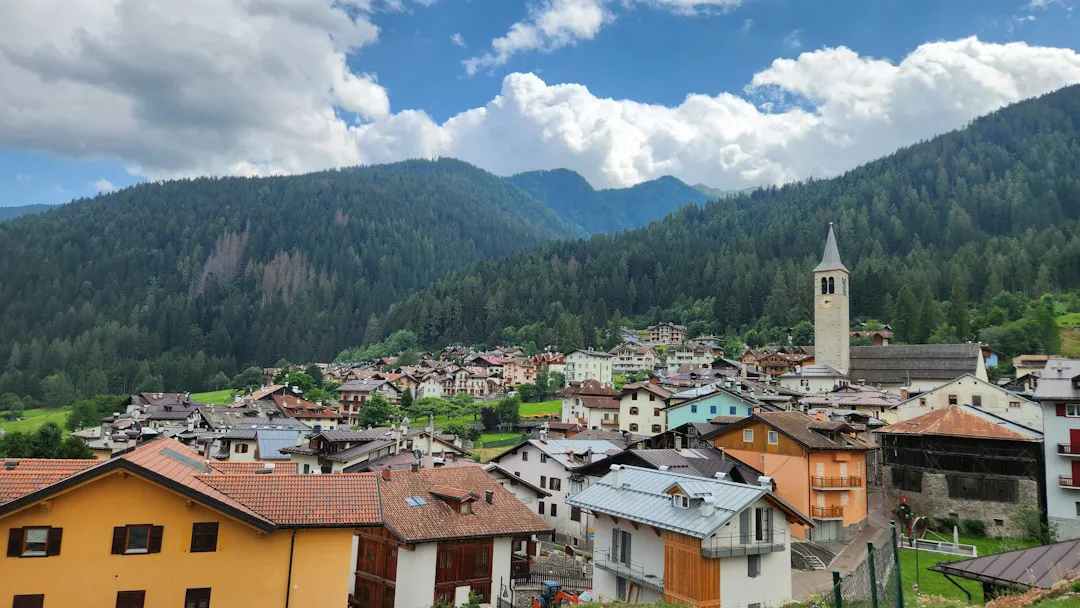 Mountain village with its bell tower among meadows and peaks